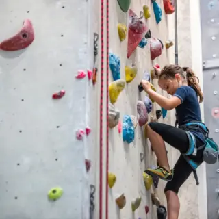 Kind klettert eine Wand hoch mit Autobelay